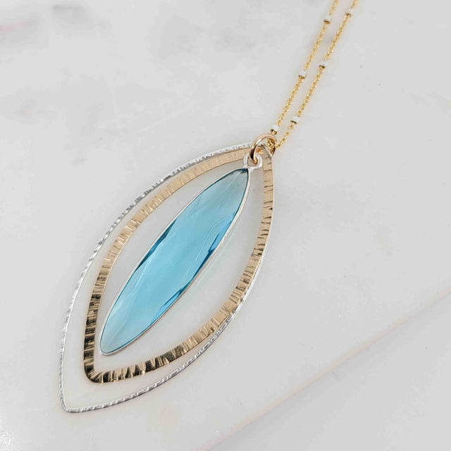 Long Marquise Shaped Blue Topaz Surrounded by Textured Double Petal Mixed Metal Necklace