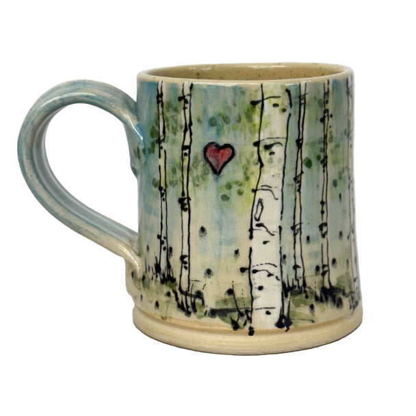 Ceramic mug with forest design and heart on a white background