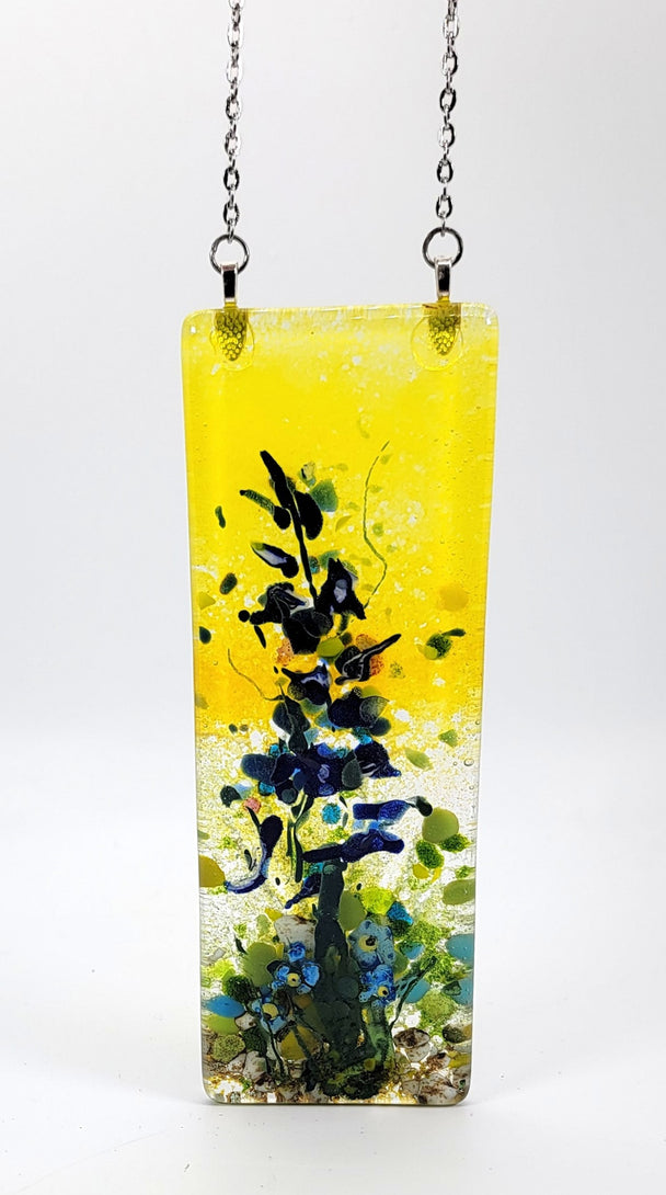 Decorative glass pendant with floral design on a yellow background