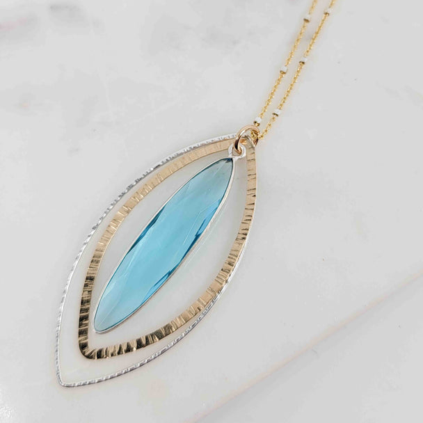 Long Marquise Shaped Blue Topaz Surrounded by Textured Double Petal Mixed Metal Necklace