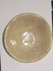 Ceramic bowl on a white sheet of paper with a blurred background