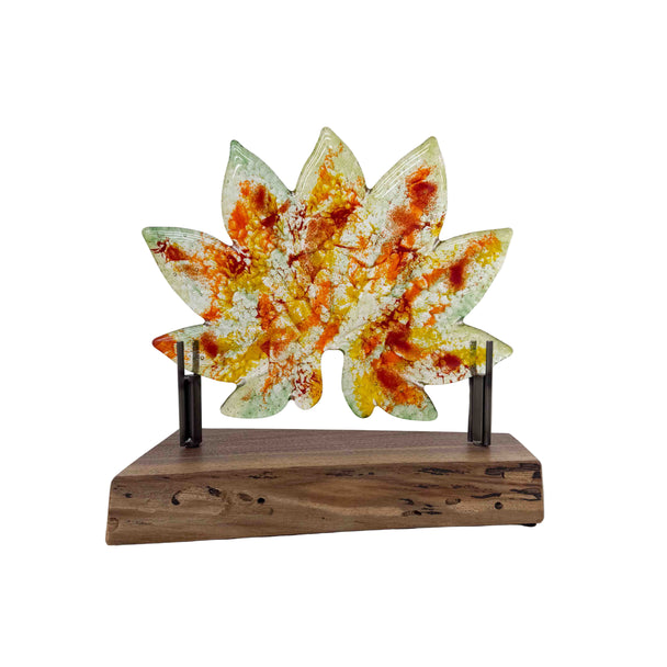 Decorative item with a colorful leaf design on a wooden base against a white background