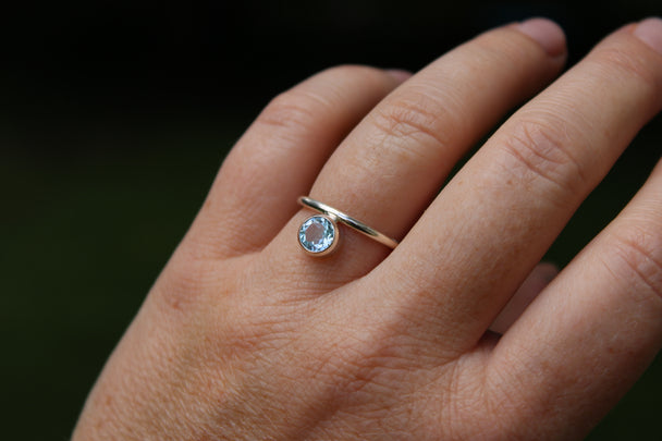 Silver Band Ring with Offset Sky Blue Topaz Stone