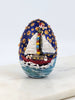 Decorative hand painted egg with snowmen sailing in holiday colors.