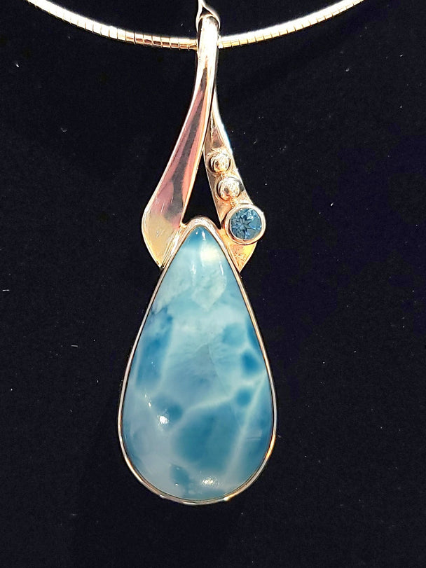 Larimar on a Sterling silver pendant with ribbon bale and blue topaz accent.