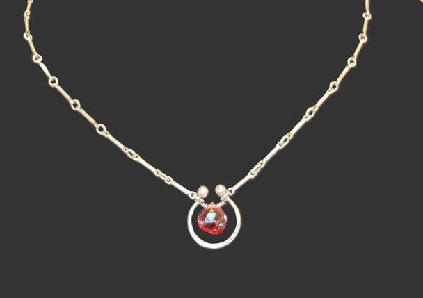 Garnet Horseshoe Sterling Silver Necklace with a black background