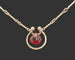 Close-up of a Garnet Horseshoe Sterling Silver Necklace with a black background